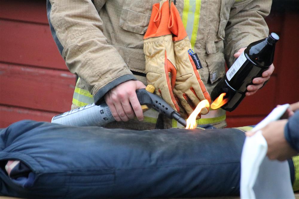 Brannkonstabel tenner på en sekk, tilsette skal slukke brannen ved hjelp av brannteppe - Klikk for stort bilete