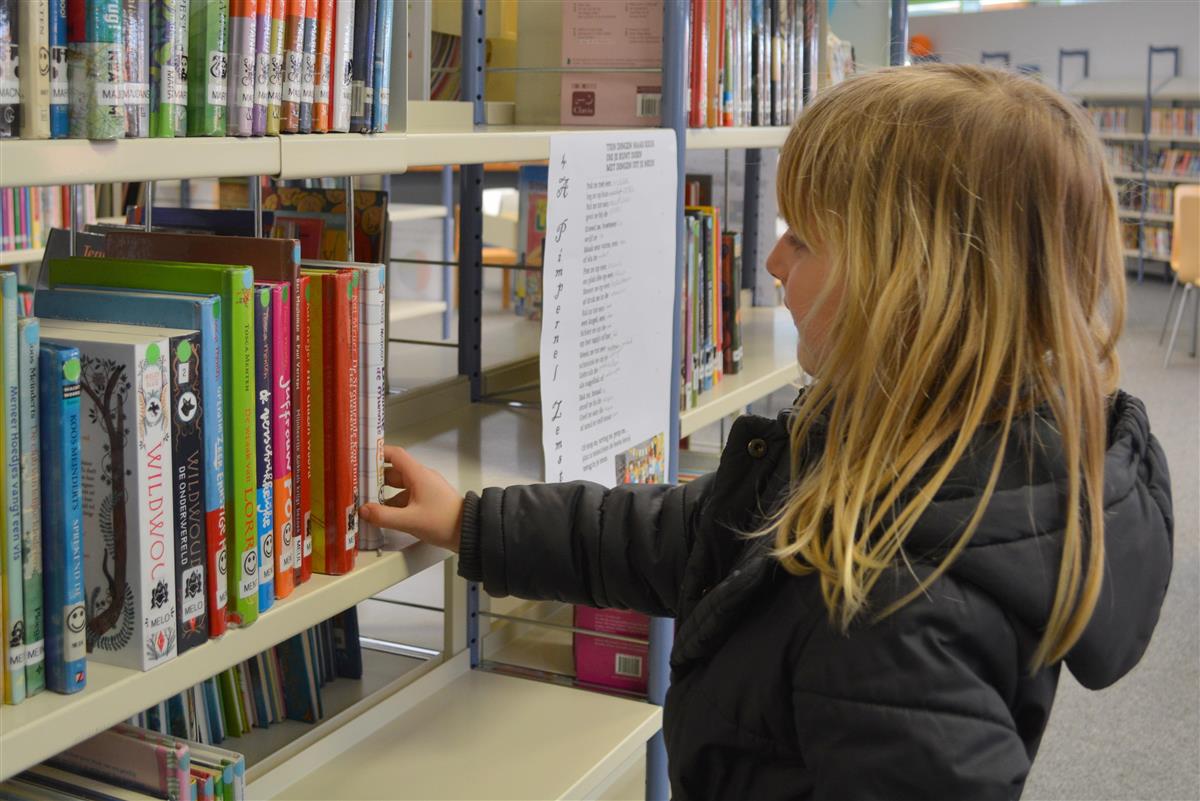 Ill. jente og bøker på bibliotek - Klikk for stort bilete