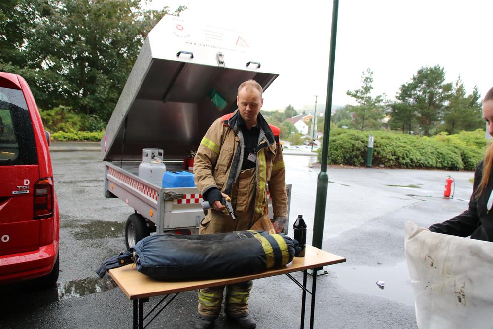 Brannkonstabel tenner på en sekk, tilsette skal slukke brannen ved hjelp av brannteppe - Klikk for stort bilete