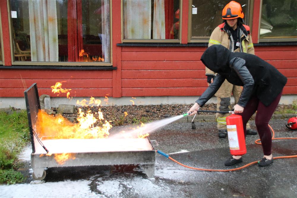 Brannvernkurs for tilsette ved Øygarden rådhus. Tilsett slukker brann ved hjelpa av brannslukkingsapparat - Klikk for stort bilete