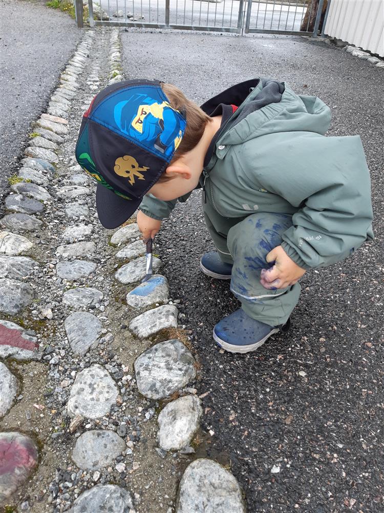 Barn som maler på steinar ute - Klikk for stort bilete