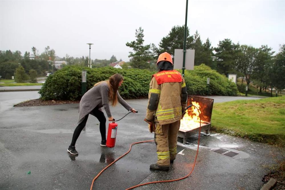 Brannvernkurs for tilsette ved Øygarden rådhus. Tilsett slukker brann ved hjelpa av brannslukkingsapparat - Klikk for stort bilete